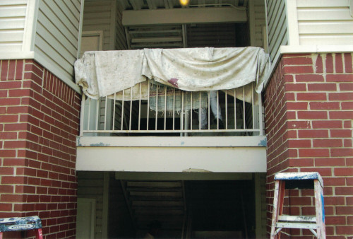 Photo of exterior patio railing covered by painters cloth.