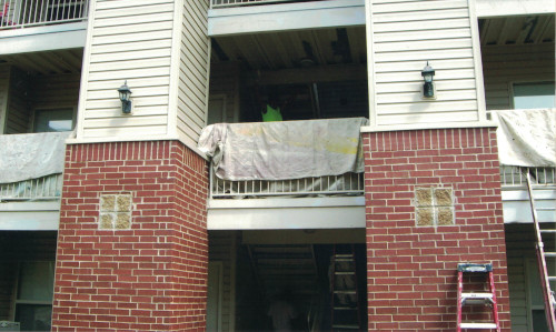 Photo of paint rolling a 12-foot high metal staircase beam.