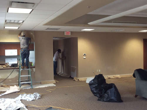 Before photo of the crew getting started on wall paper removal.