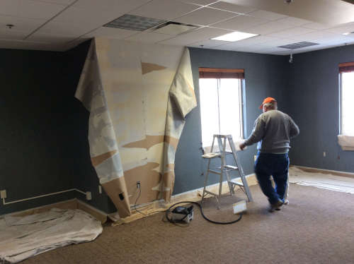 Photo of a whole corner of wall paper removal being started.