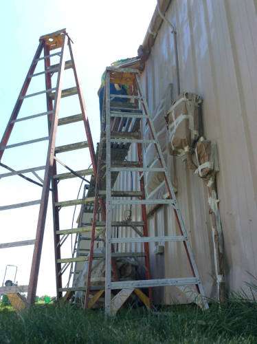 A photo of Scott riding on the mechanical lift that was used to do the tall side of the house where ladders wouldn't work.