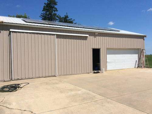 After shot of the rear side of the beautiful Iowa country home with freshly painted exterior walls and decks.
