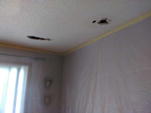 Before photo of a few holes in an otherwise nice suburban family dining room ceiling.