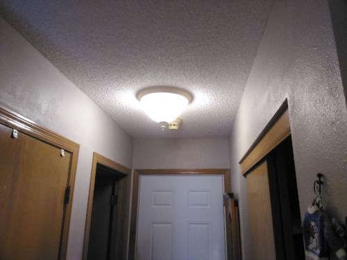 After shot of one of the adjoining hallway area's ceiling freshly textured and painted.